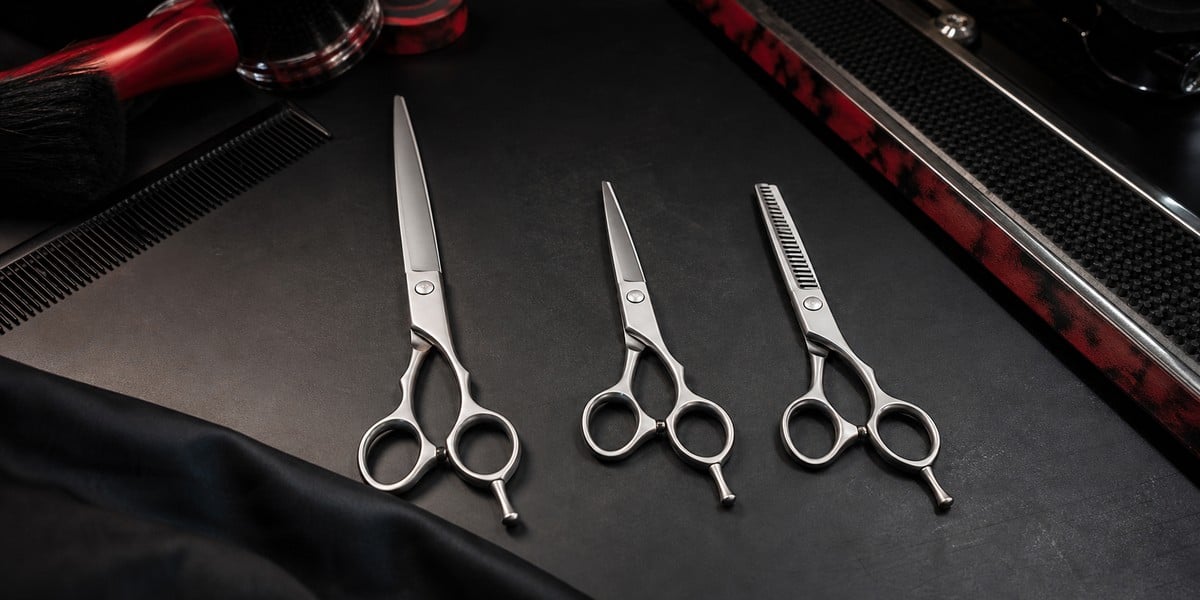 Barber shears, salon hair scissors and thinning shears compared on a professional barber workbench